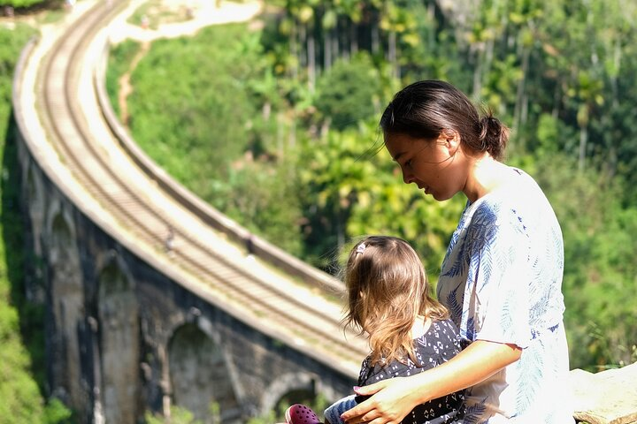 Travelers sitting and enjoying the view of Nine arch bridge in Ella, Sri Lanka